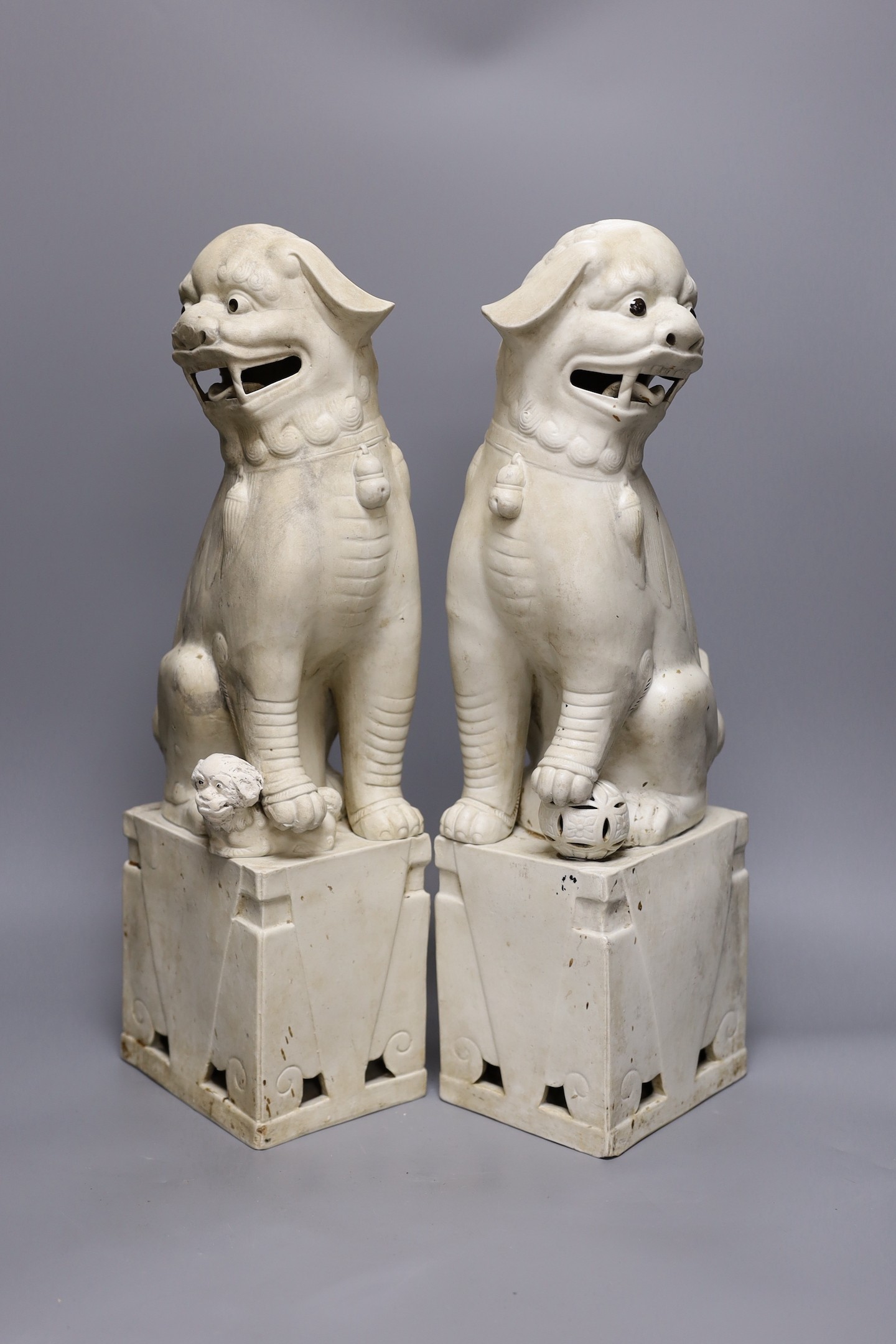 A pair of large Chinese biscuit porcelain lion-dog figures, 45cms high